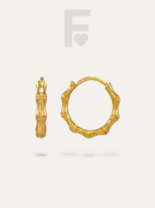 Detalle pendiente de aro bambú, acero quirúrgico hipoalergénico, joyería minimalista.